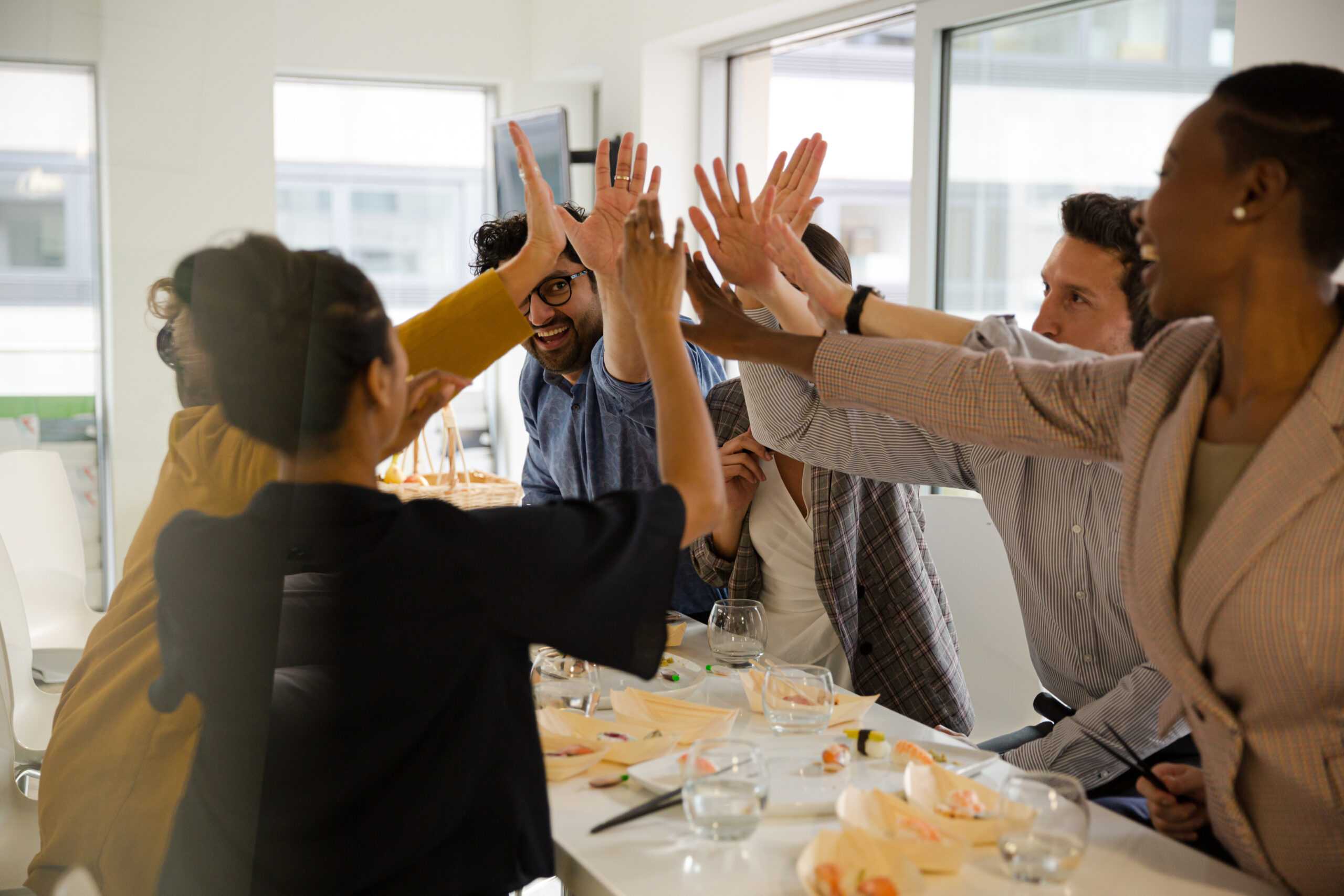 Happy business people touching hands, celebrating success with s
